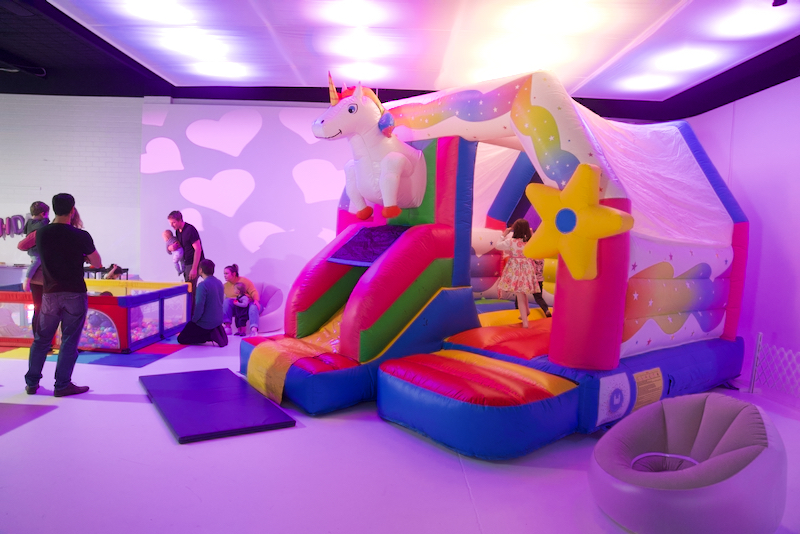 A rainbow unicorn bouncy castle at a kids birthday party